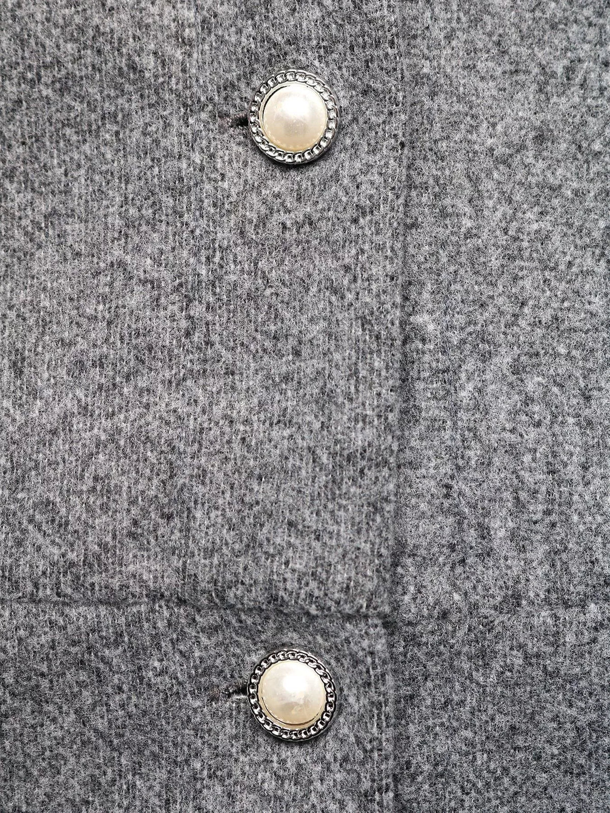 Close-up of gray wool fabric with pearl decorative buttons, trendy fashion detail from Shopimist