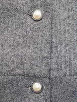 Close-up of gray wool fabric with pearl decorative buttons, trendy fashion detail from Shopimist