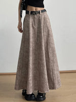 Woman wearing taupe pleated maxi skirt with black belt and chunky shoes, stylish fashion