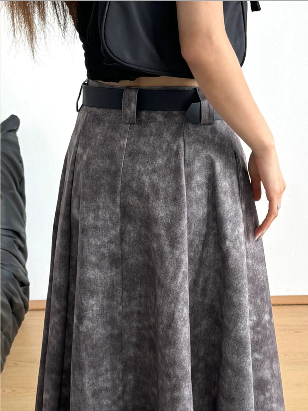 Woman in black top and grey pleated skirt with belt, Shopimist trendy women's apparel
