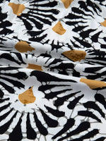 Abstract black and gold floral pattern on white fabric, close-up, trendy Shopimist fashion textile
