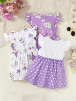 Three girls’ summer dresses with floral, heart, and fairy prints in purple and white on a textured surface, styled with sunglasses, flowers, and a plush toy. Kids’ fashion apparel from Shopimist.